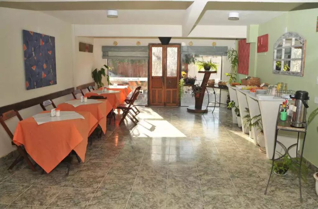 Mesas com toalhas laranja e comidas no salão de café da manhã da pousada das Américas Búzios 